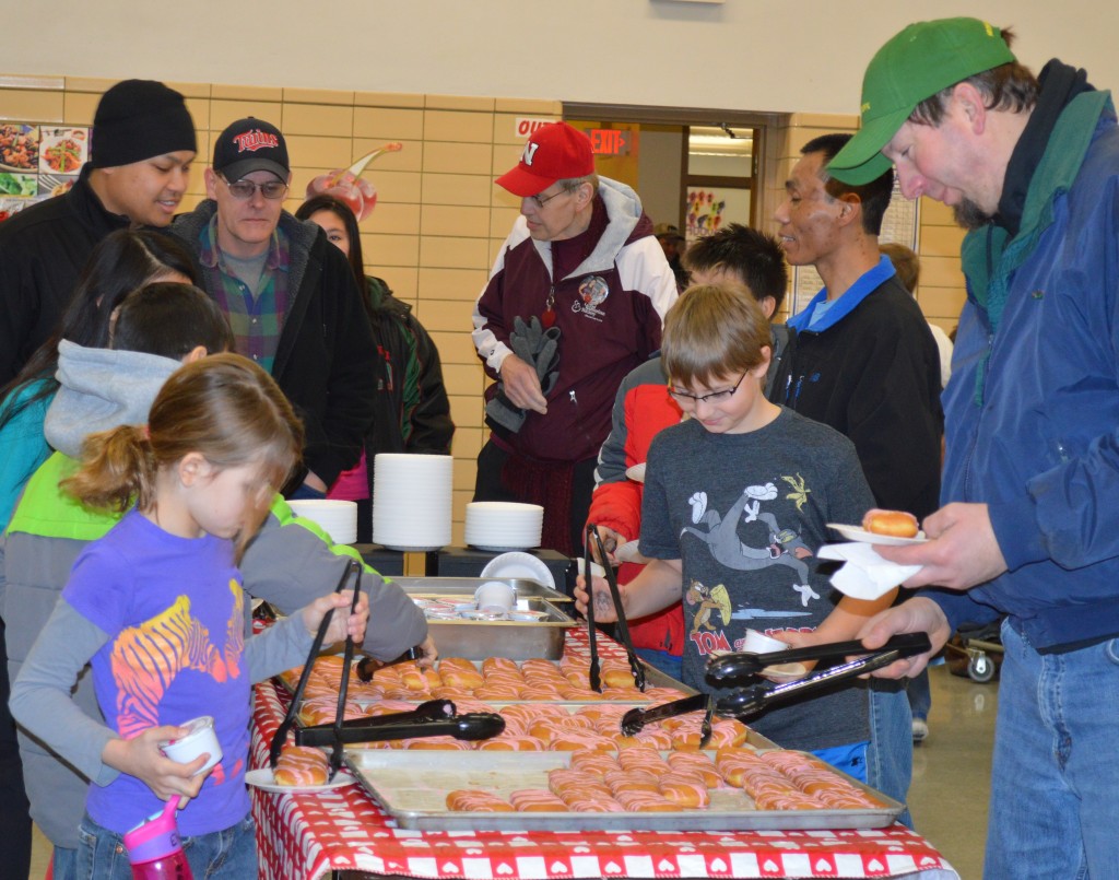 ELEMENTARY STUDENTS AND their dads or granddads or special male mentor form lines to pick up frosted donuts, along with milk or juice, to enjoy during the special morning moments.