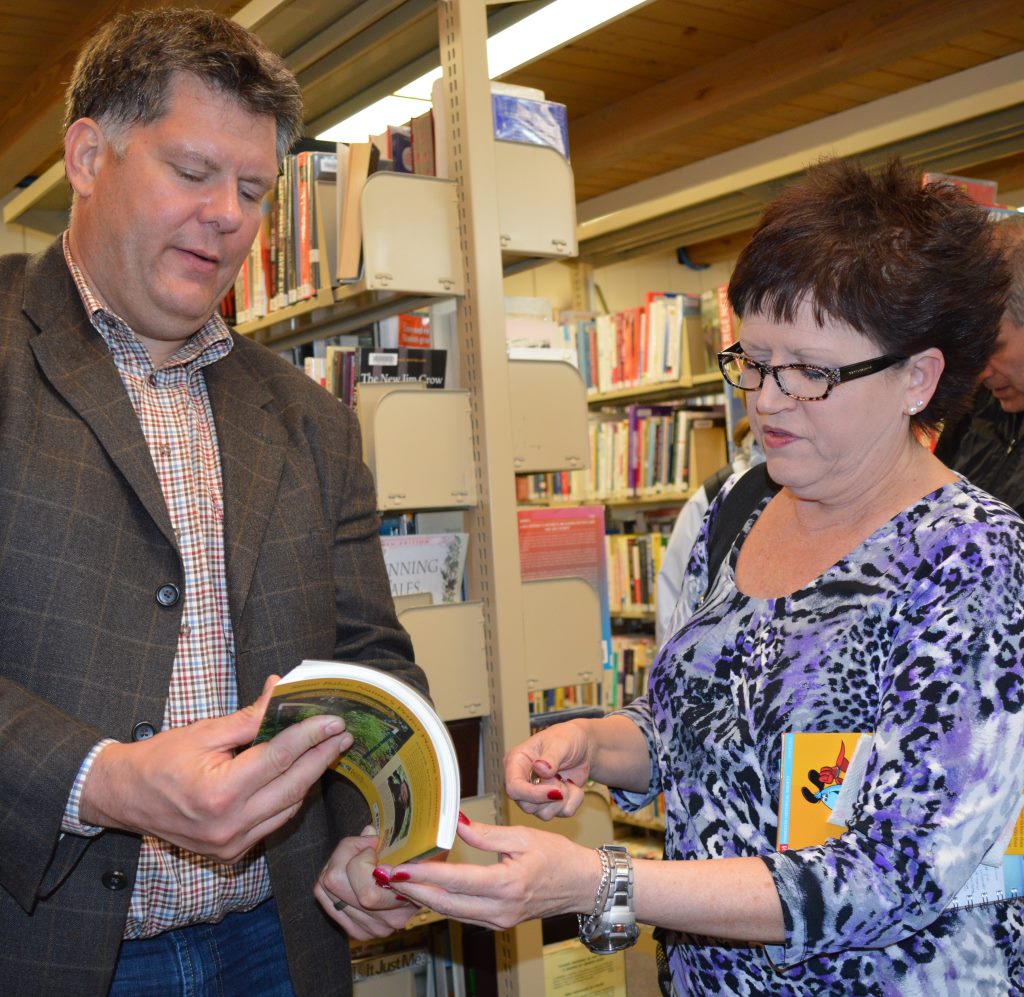 DEB JELLEMA, RIGHT, receives an autographed book from author Joel Karsten.