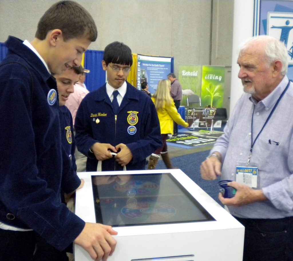 Daniel Nelson, Caleb Rempel and Daniel Harder and the National Convention Career Fair talking with company Representative.