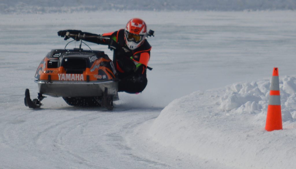 THIS RACER HAS most of his body off the Yamaha sled as he leans into the curve. Note the GoPro camera on his helmet to capture on video the race from the perspective of the driver.