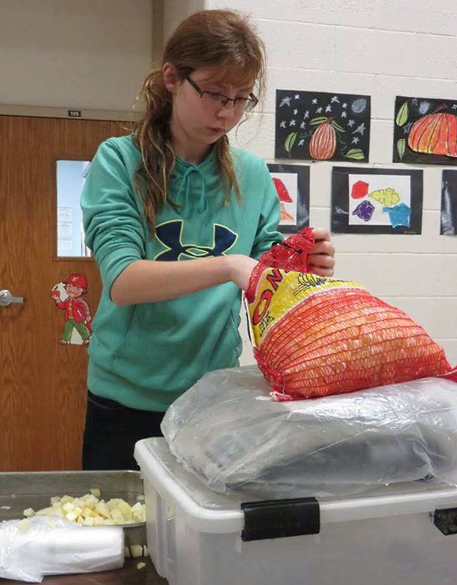 ELIZABETH LINSCHEID WEIGHING the bags of potatoes. (Photo courtesy of Dee Stoesz)